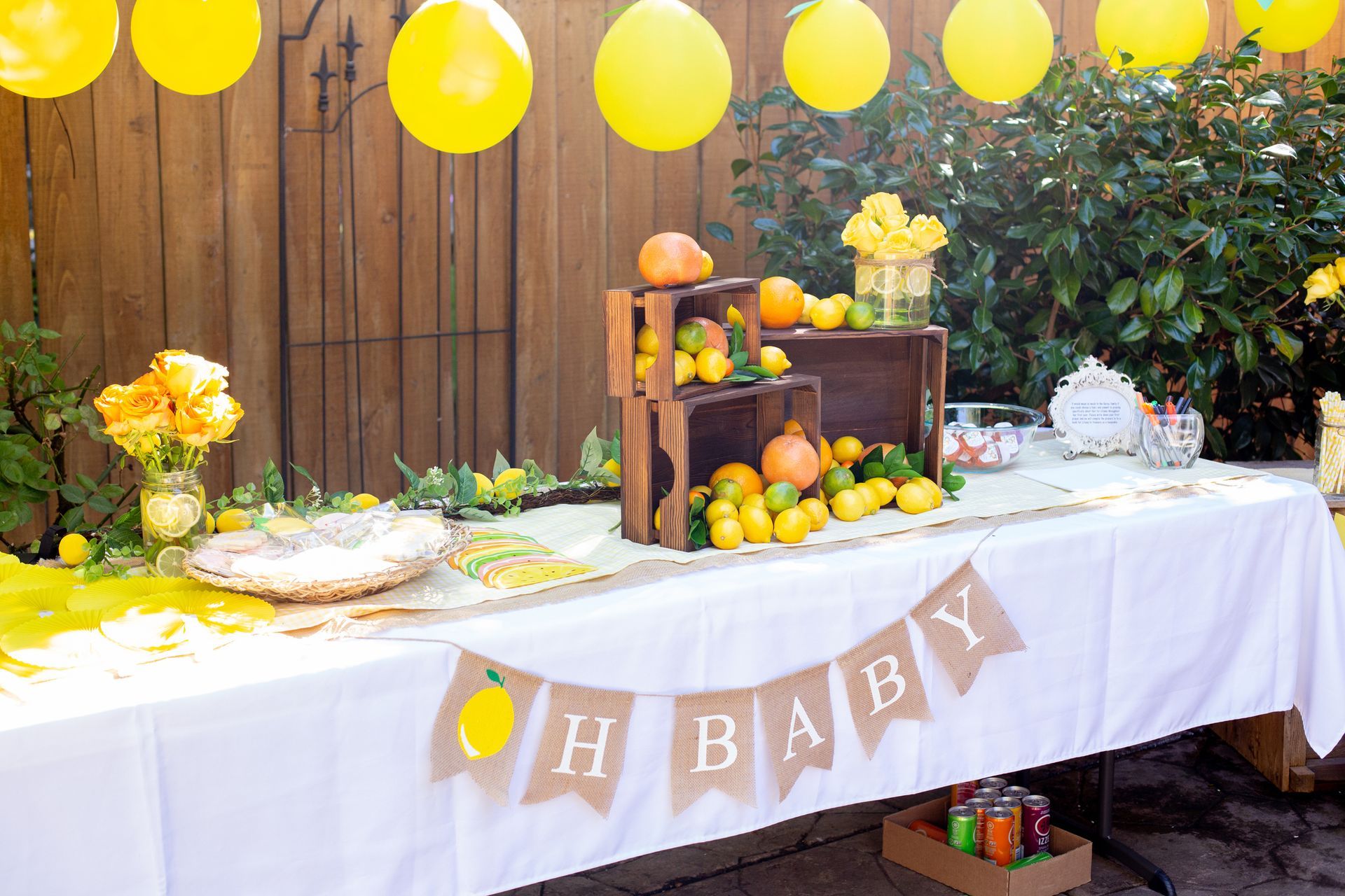 A table decorated with lemons and balloons for a baby shower.