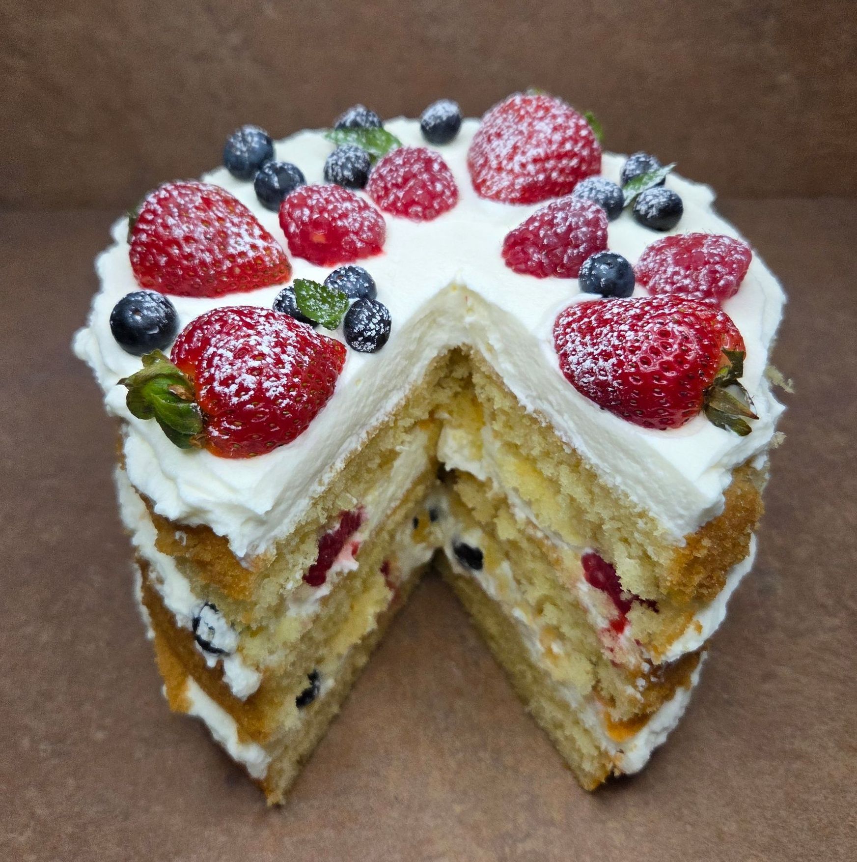 Chez Panise Chantilly Cake with a slice taken out