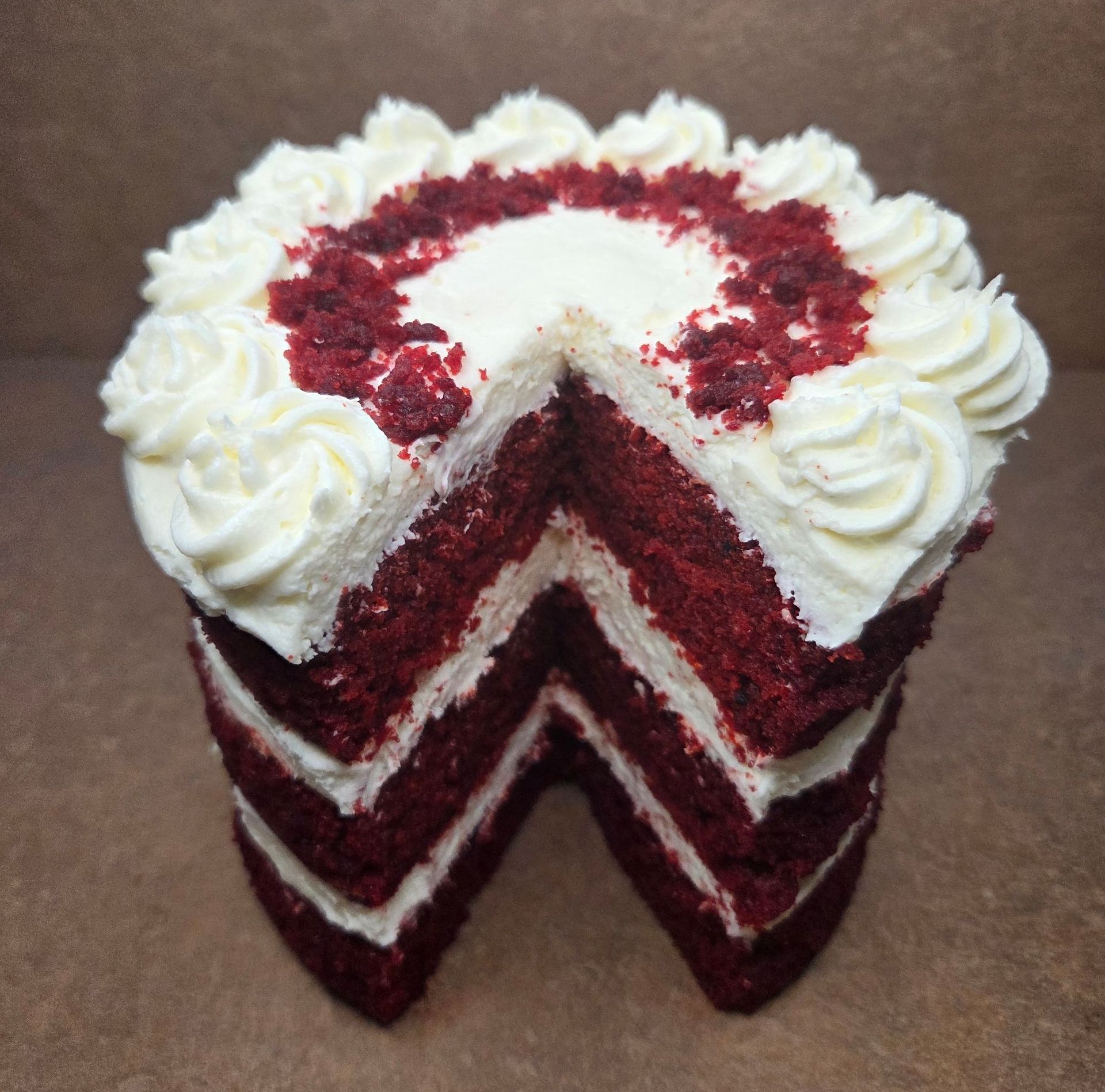 Overhead view of a red velvet cake with a slice taken out