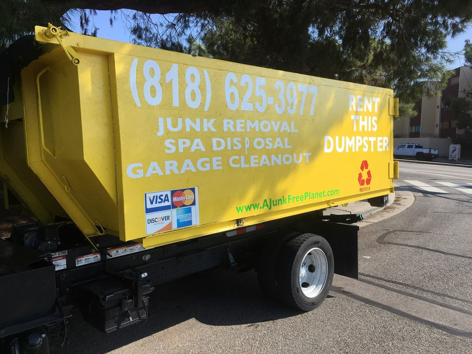 Yellow dumpster truck with text