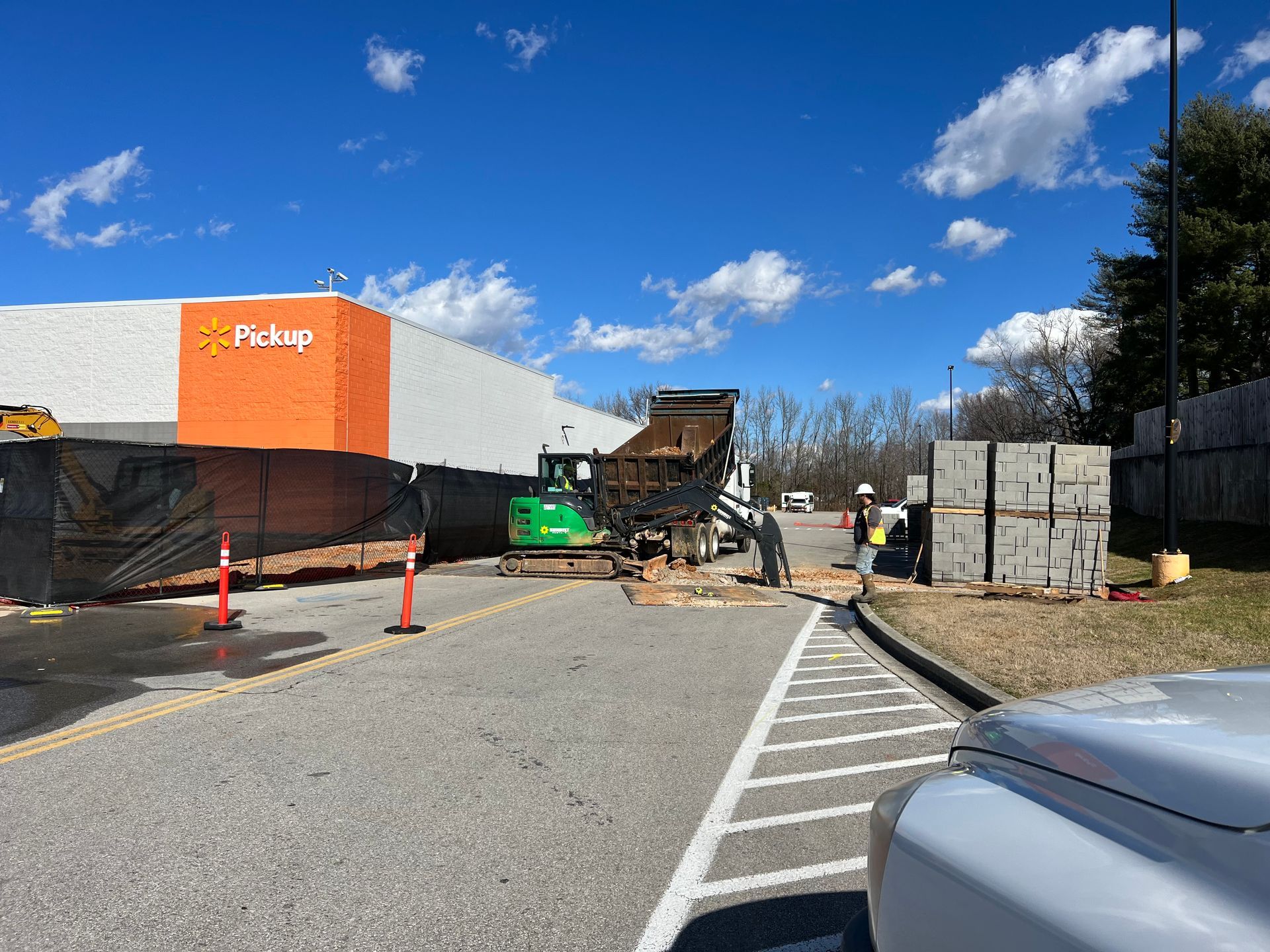 A white truck is parked in front of a building under construction.