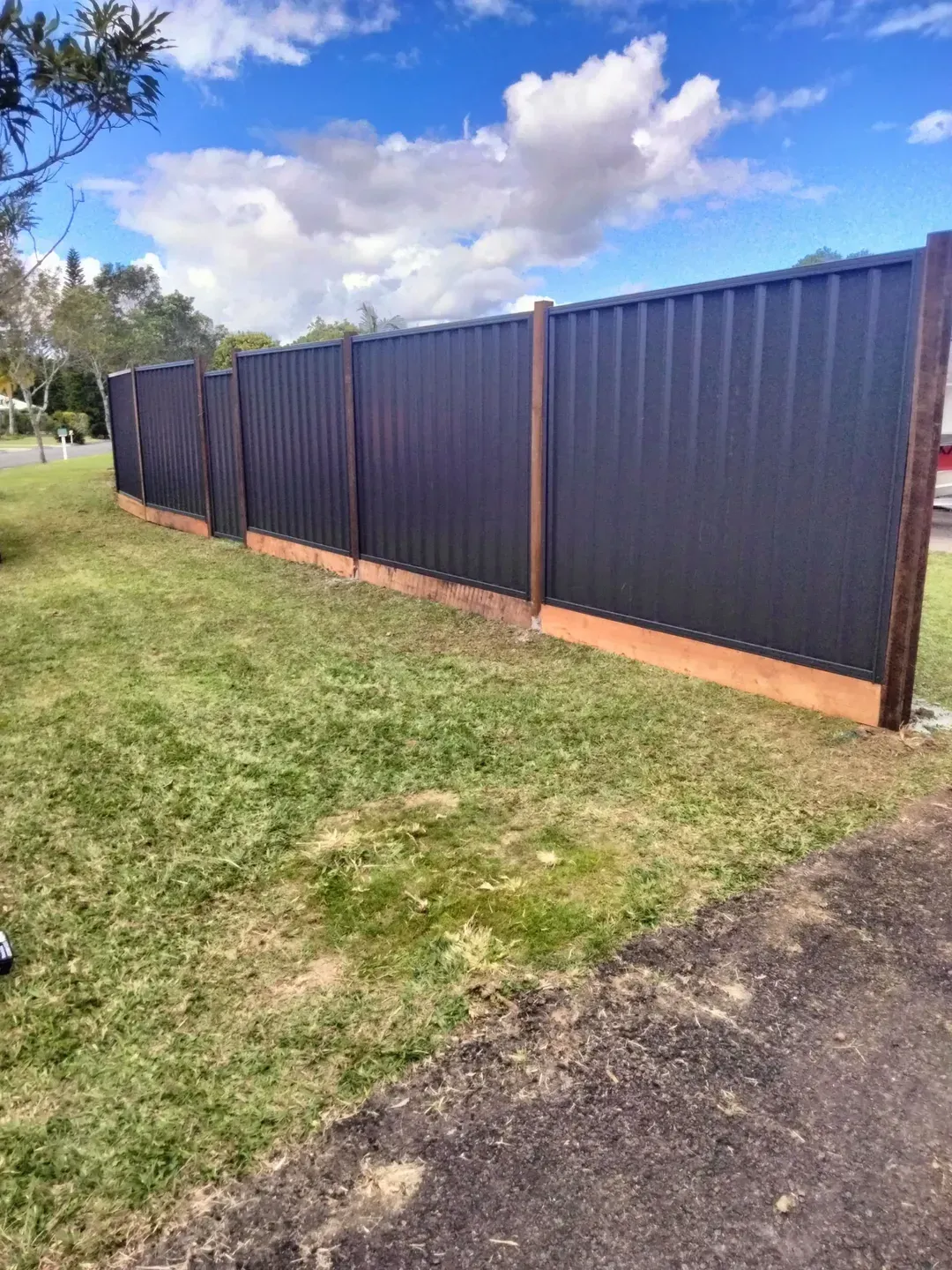 A Black Colorbond Fence on Front Lawn — Tuff Fencing in Caboolture, QLD