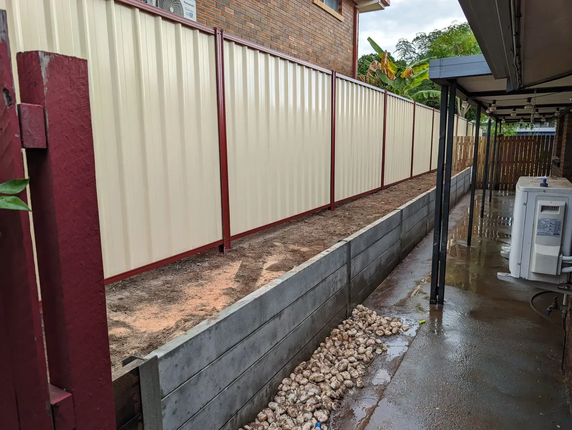A Colorbond Fence supported by Wooden Sleepers — Tuff Fencing in Caboolture, QLD
