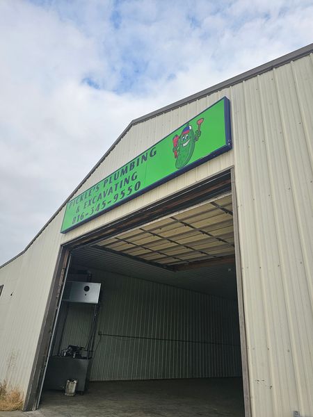 A white building with a green sign on the front of it.
