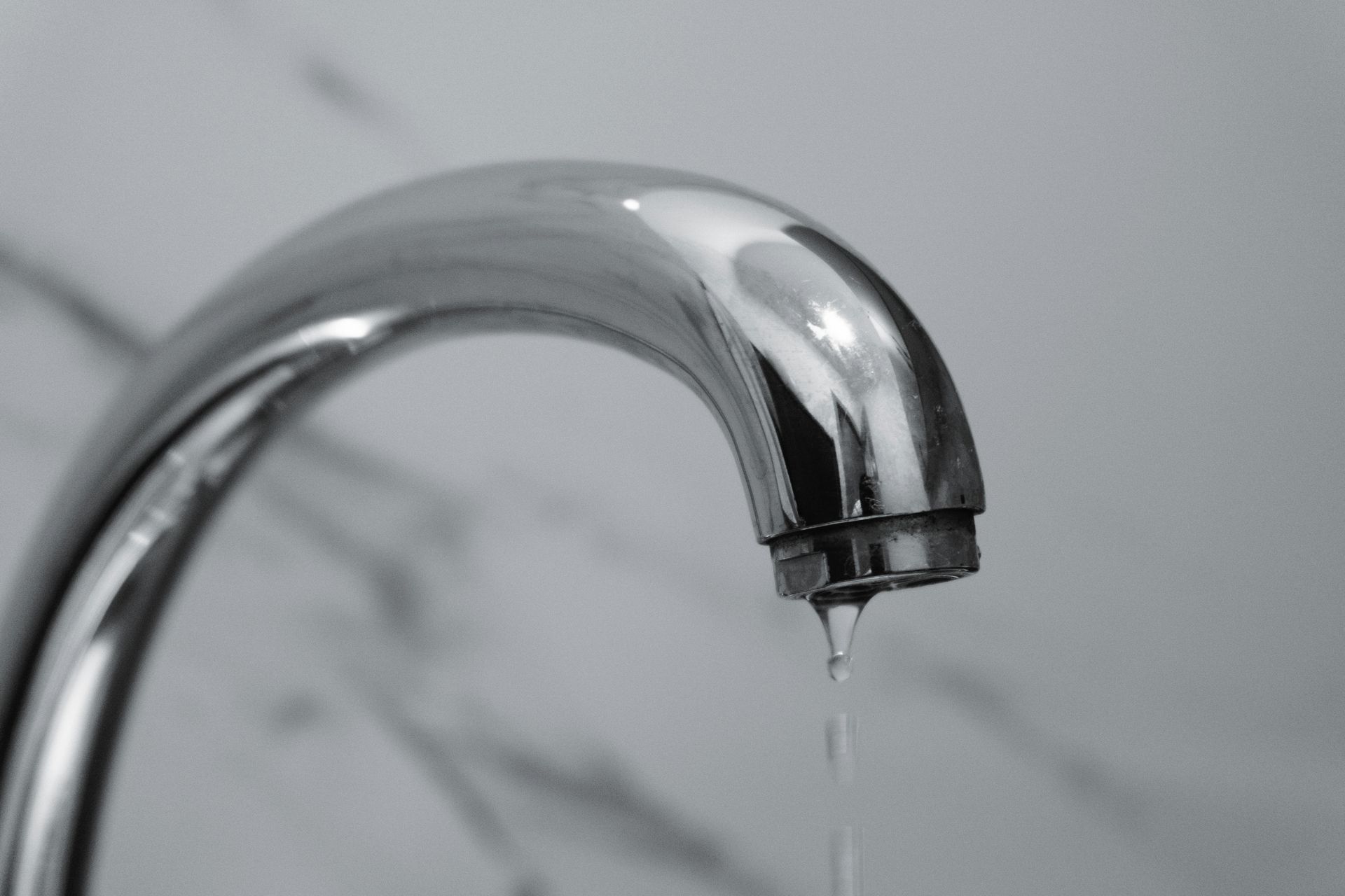 A close up of a copper pipe that is leaking water.
