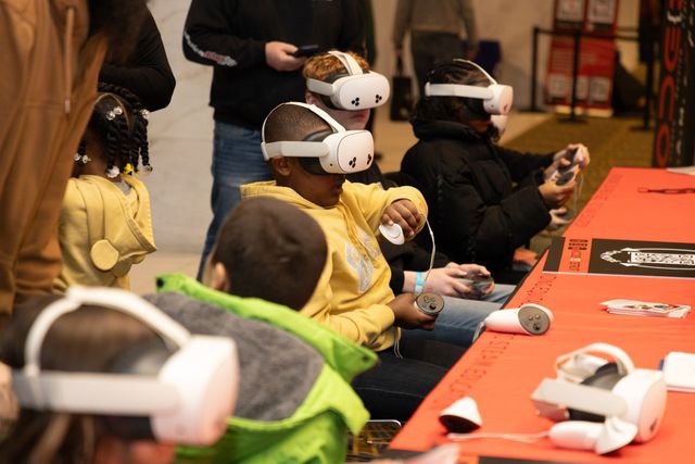 Scholars using VR headsets at the Detroit Auto Show