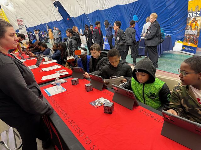 CODE313 booth with scholars and visitors