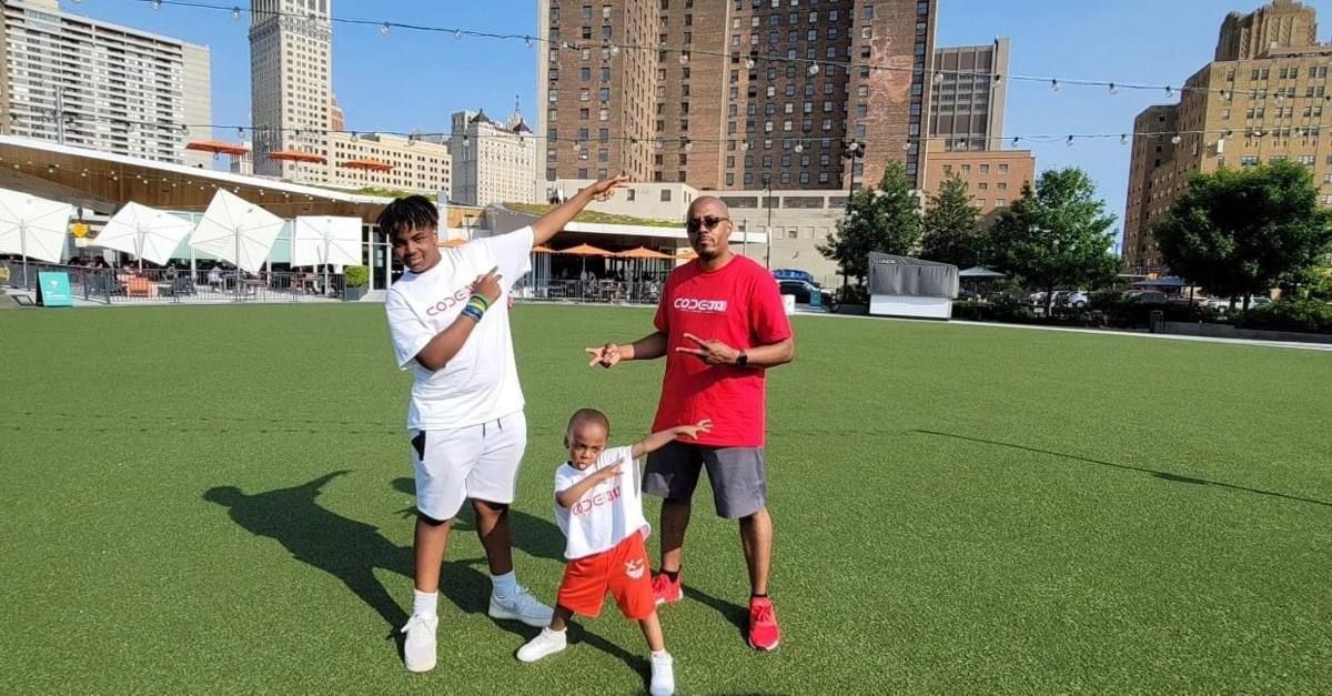 CODE313 staff and young scholars playing on the lawn at Beacon Park under a blue sky