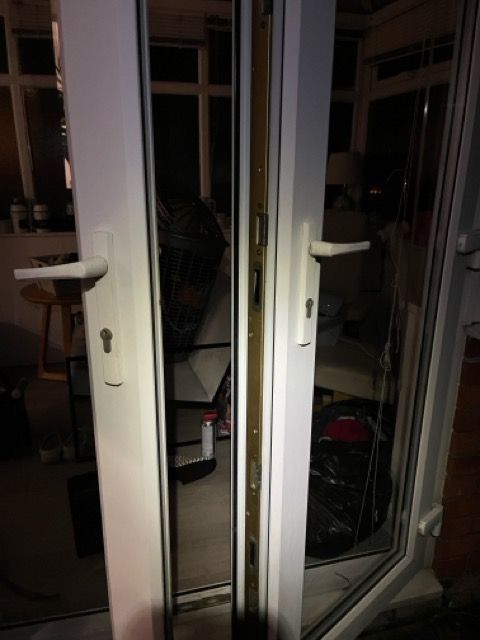 Open white French doors at night, with a dim interior visible through the glass.