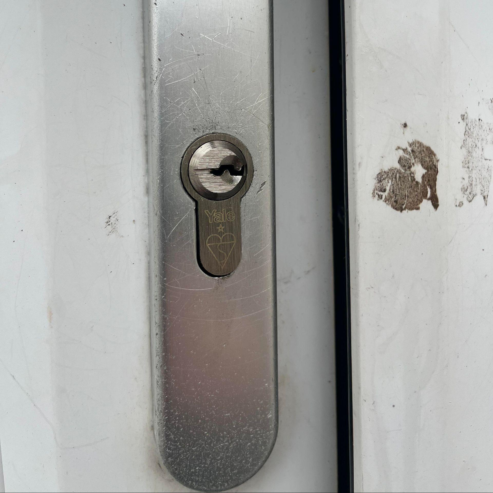 Silver door lock, keyhole visible, on white door.