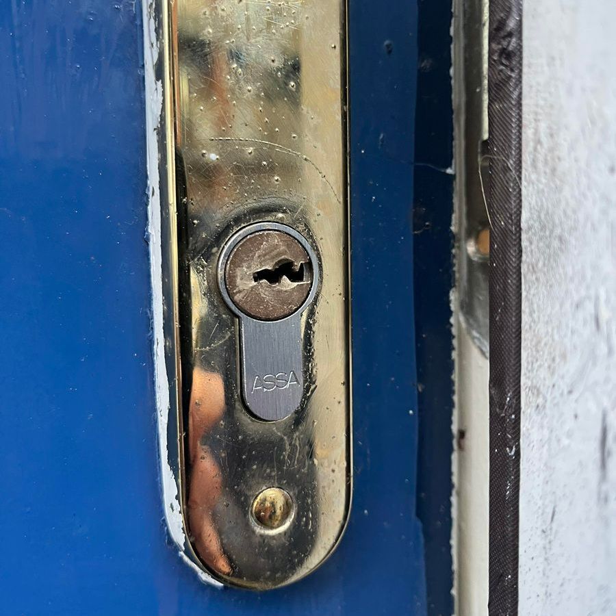 Close-up of a brass door handle with a keyhole labeled
