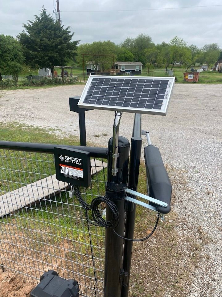 A solar panel is sitting on top of a fence post.