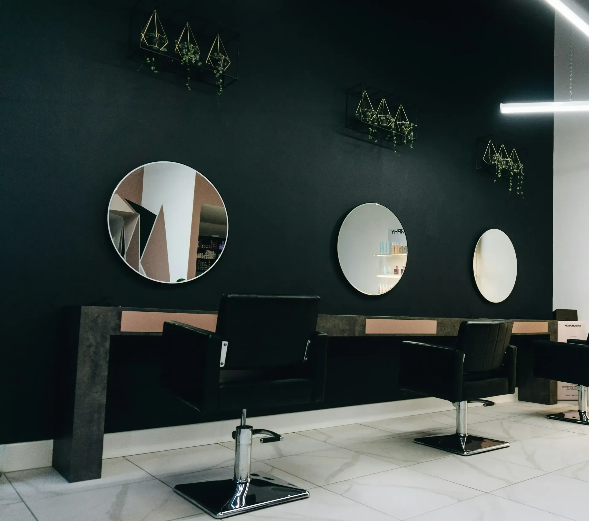 A hair salon with chairs and mirrors on the wall