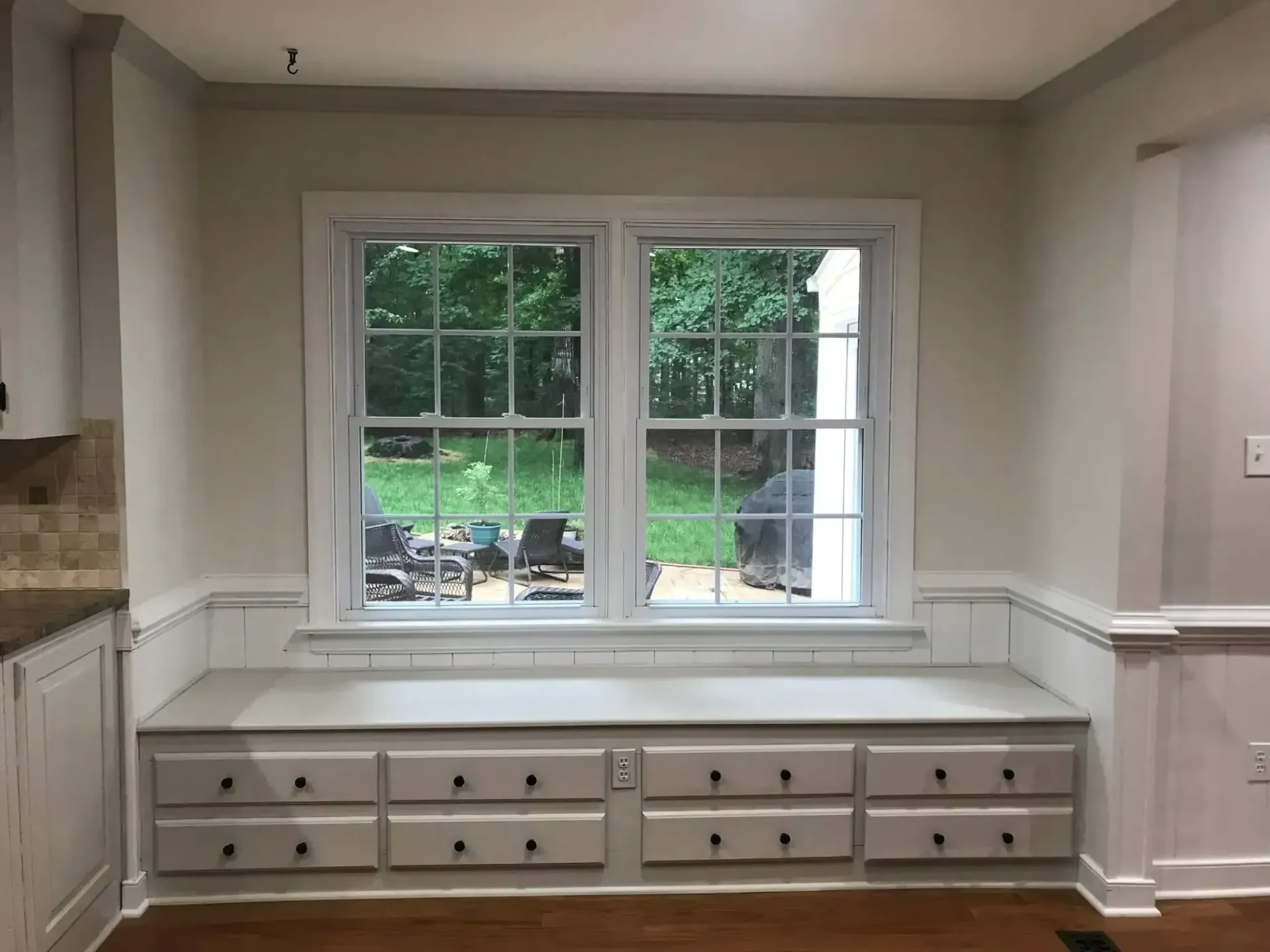 A kitchen with a window and a bench with drawers underneath it