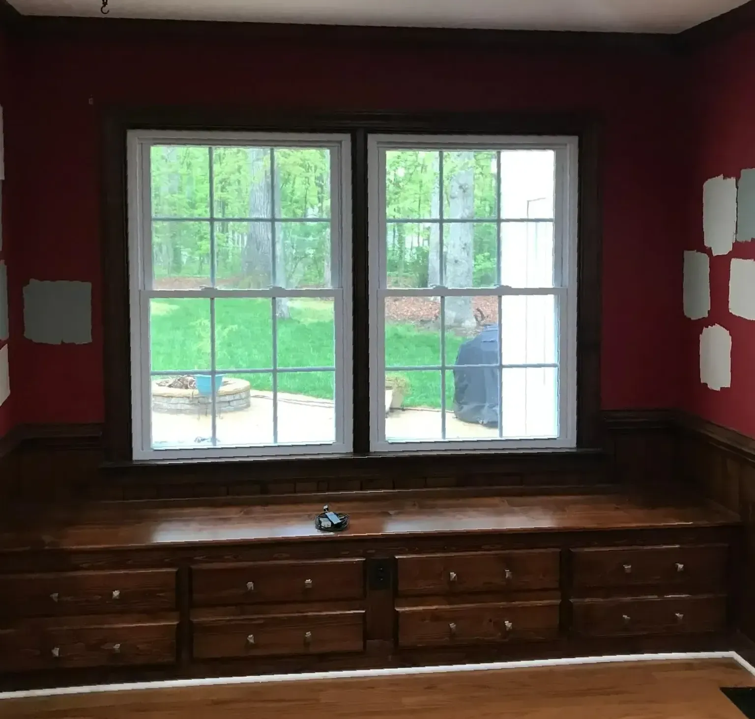 A room with a window and a bench with drawers underneath it
