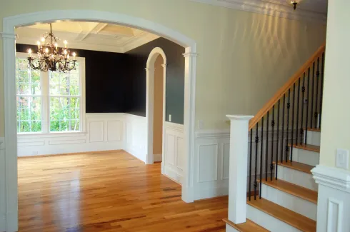 An empty house with stairs and a chandelier