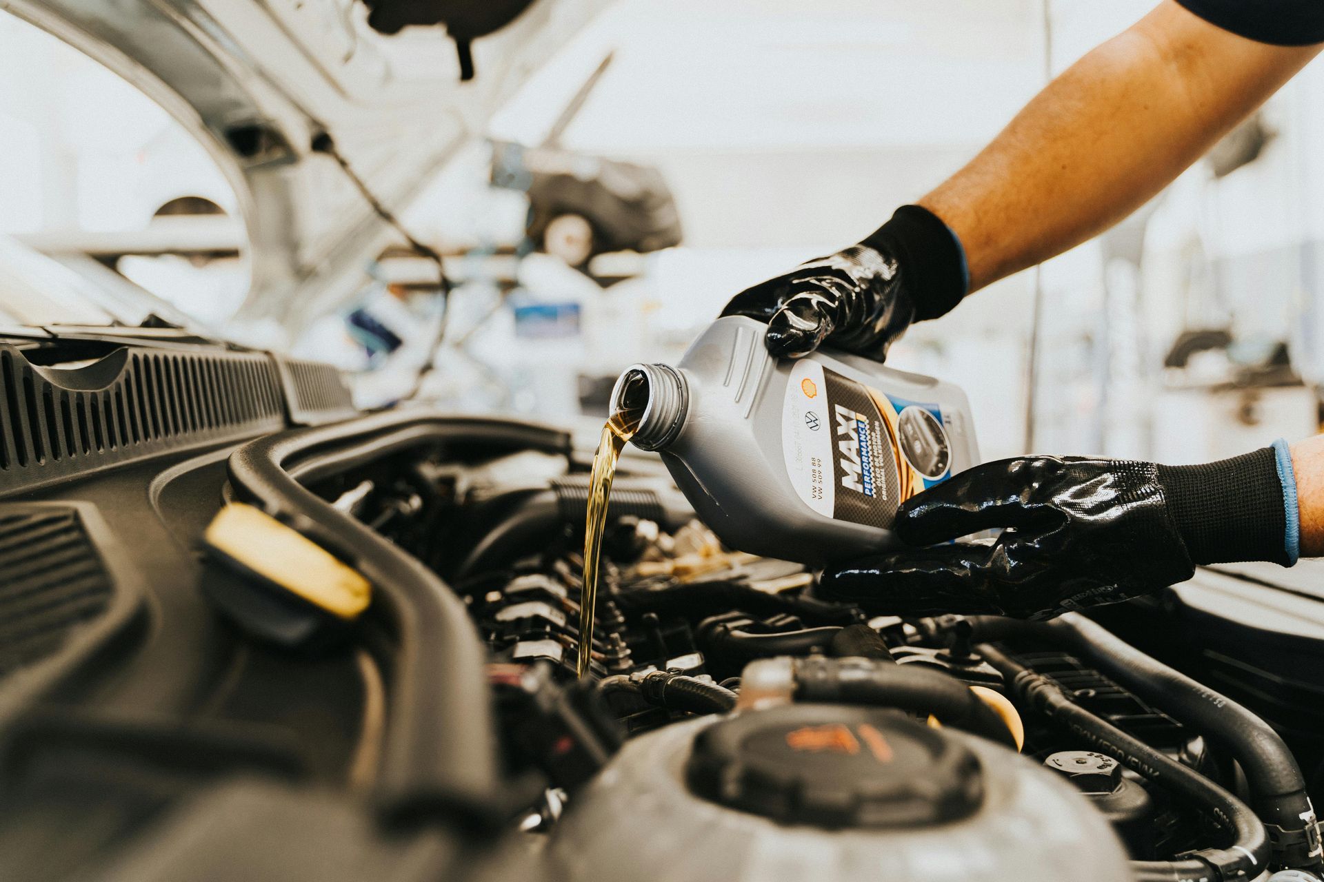 Auto Technician Pouring Engine Oil During Vehicle Service | Norgren's Auto Center