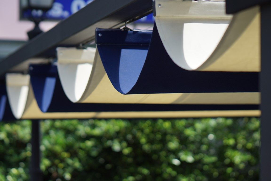 A blue and white awning is hanging from a pole
