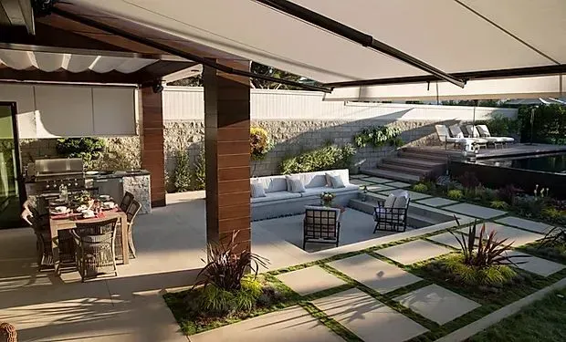 A patio with a table and chairs under an awning.