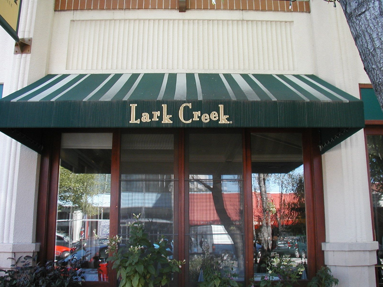 A before and after photo of a green awning on a building.