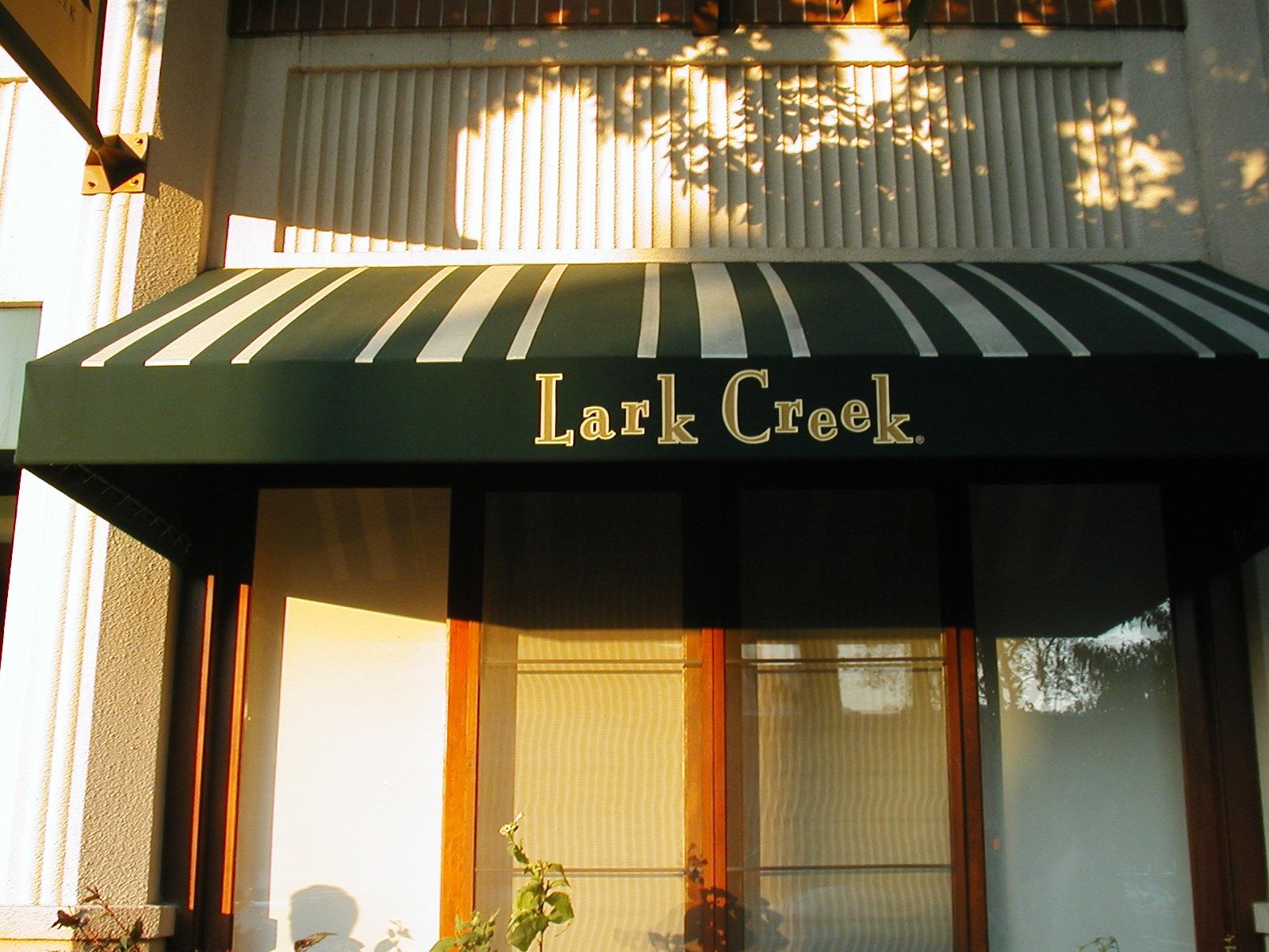 A before and after photo of a store with a blue awning.