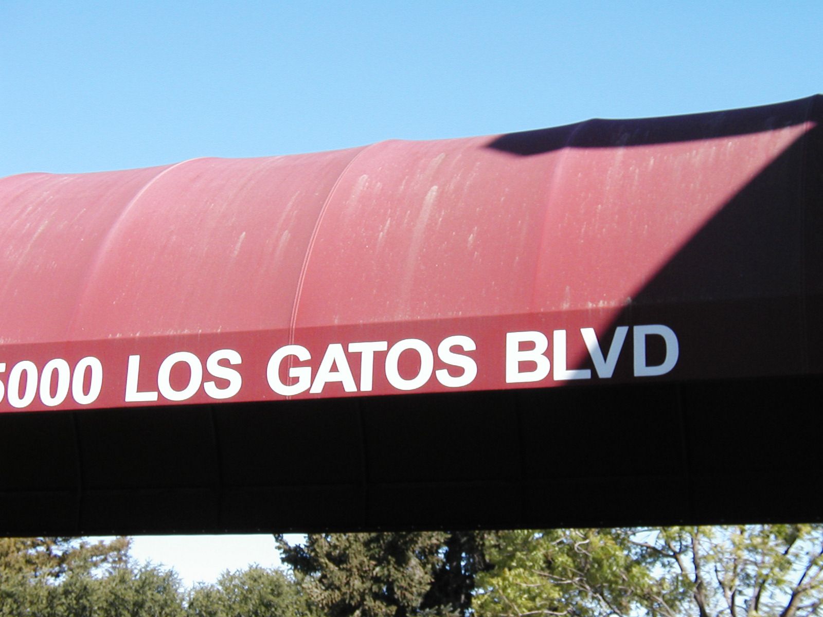 A before and after photo of a red and white striped awning