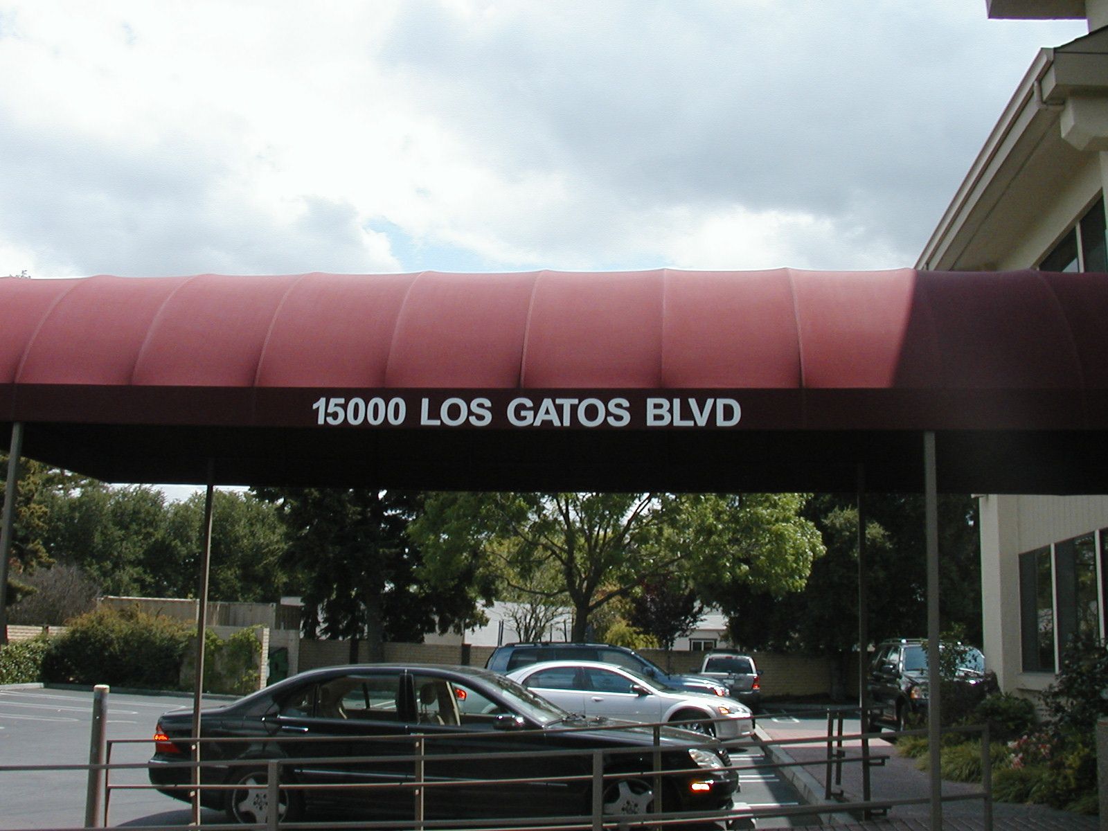 A pink and purple awning is on the side of a building.