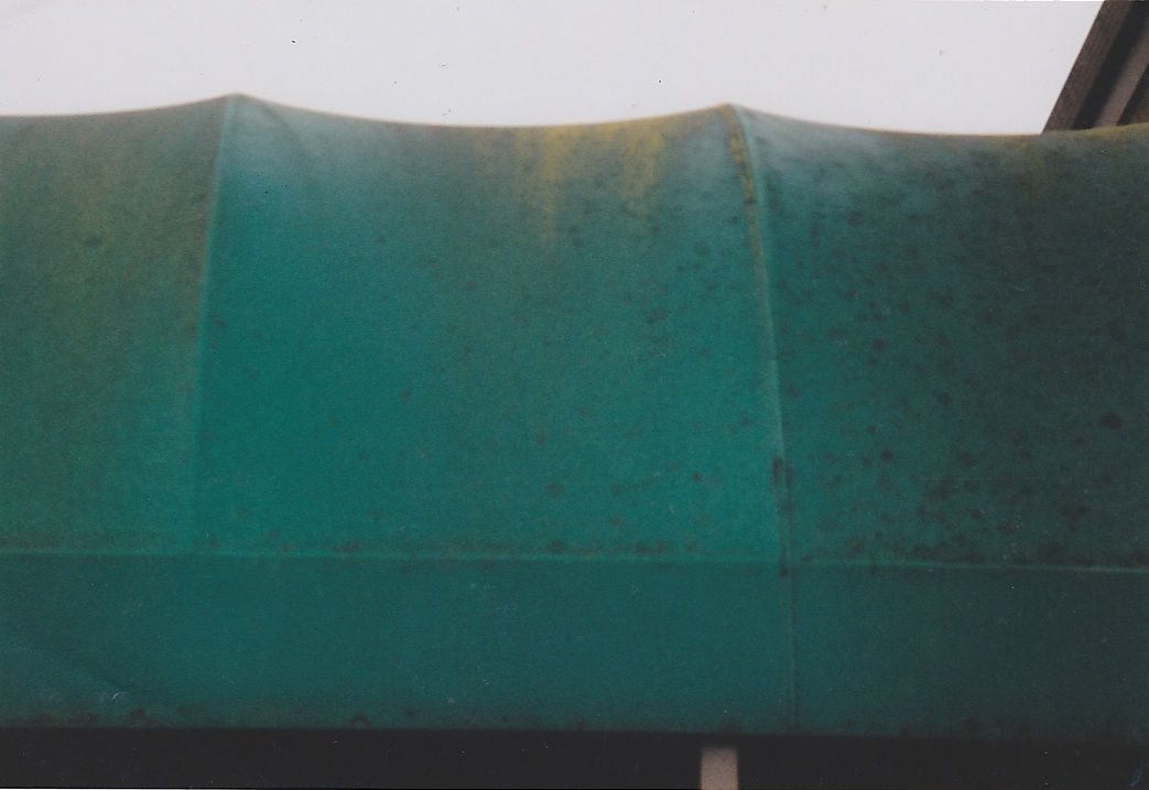 A before and after photo of a green awning on a building.