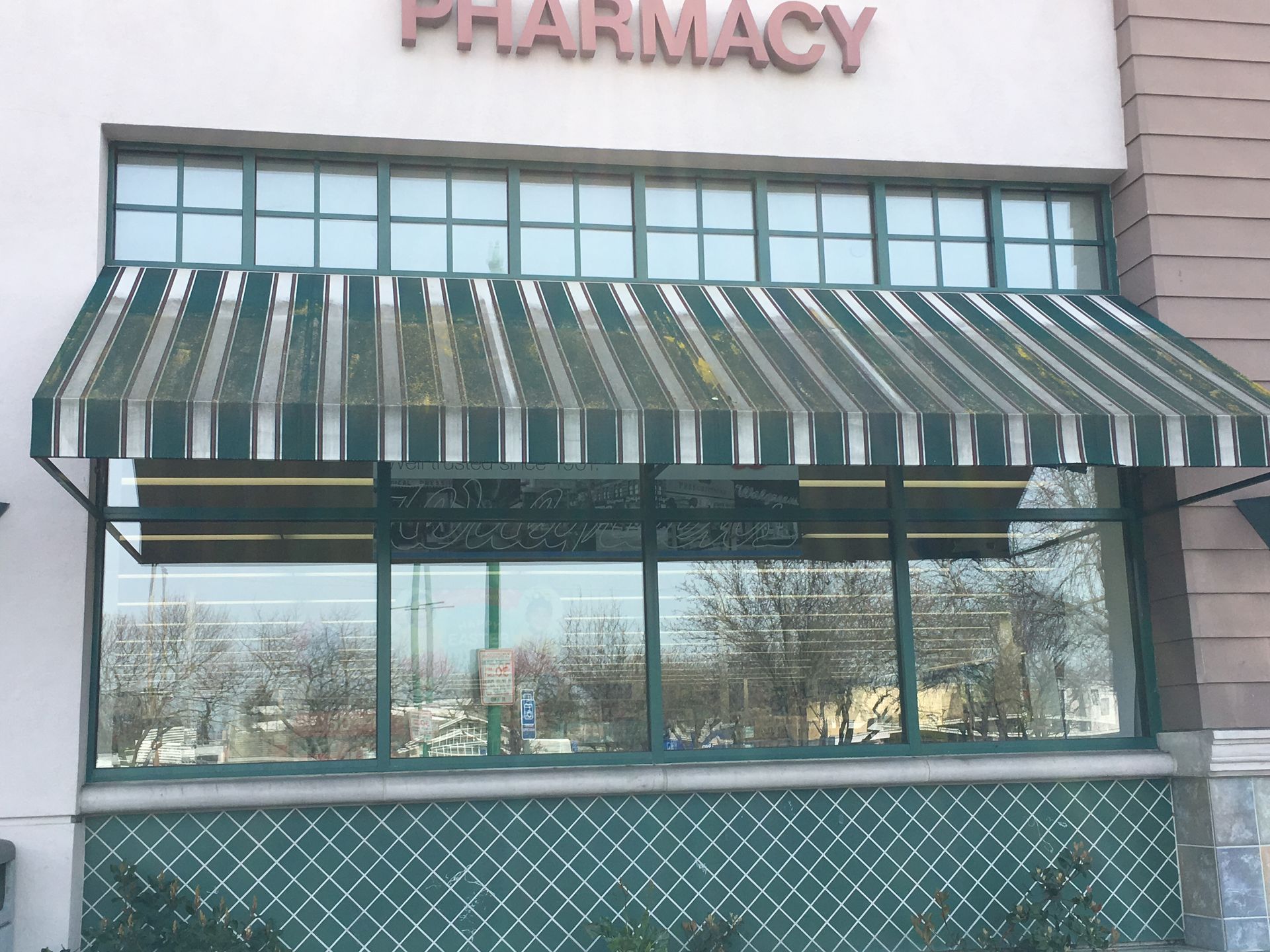 A before and after photo of a green awning on a building.
