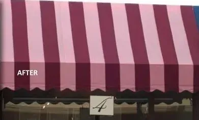 A pink and purple awning is on the side of a building.