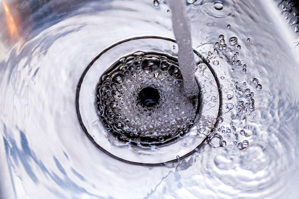A close up of a sink with water running down the drain