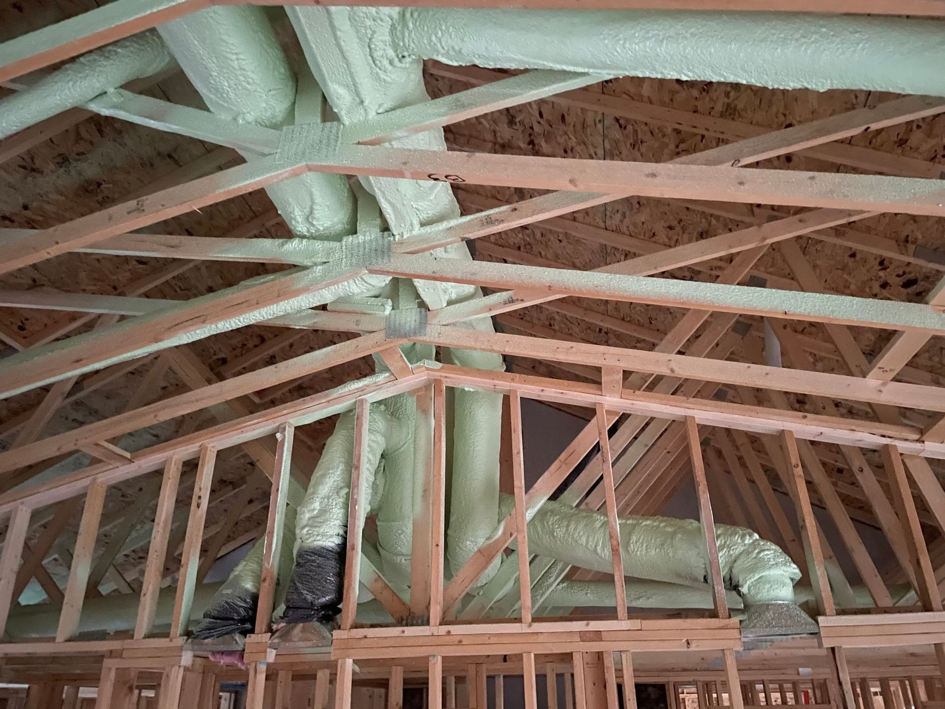 Insulated attic with exposed wooden roof trusses and beams