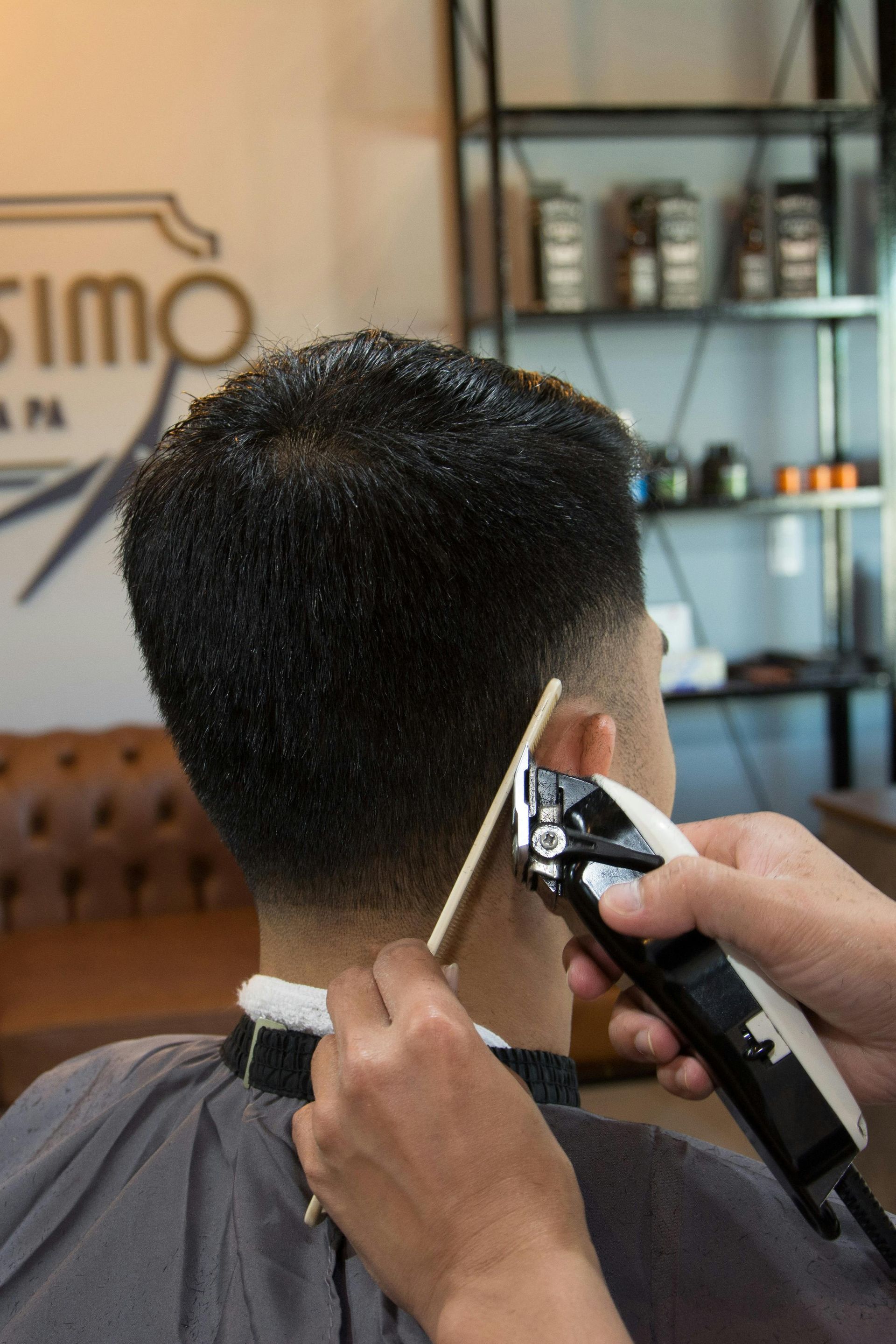 Hair stylist curling client's blonde hair with a curling iron in a salon.