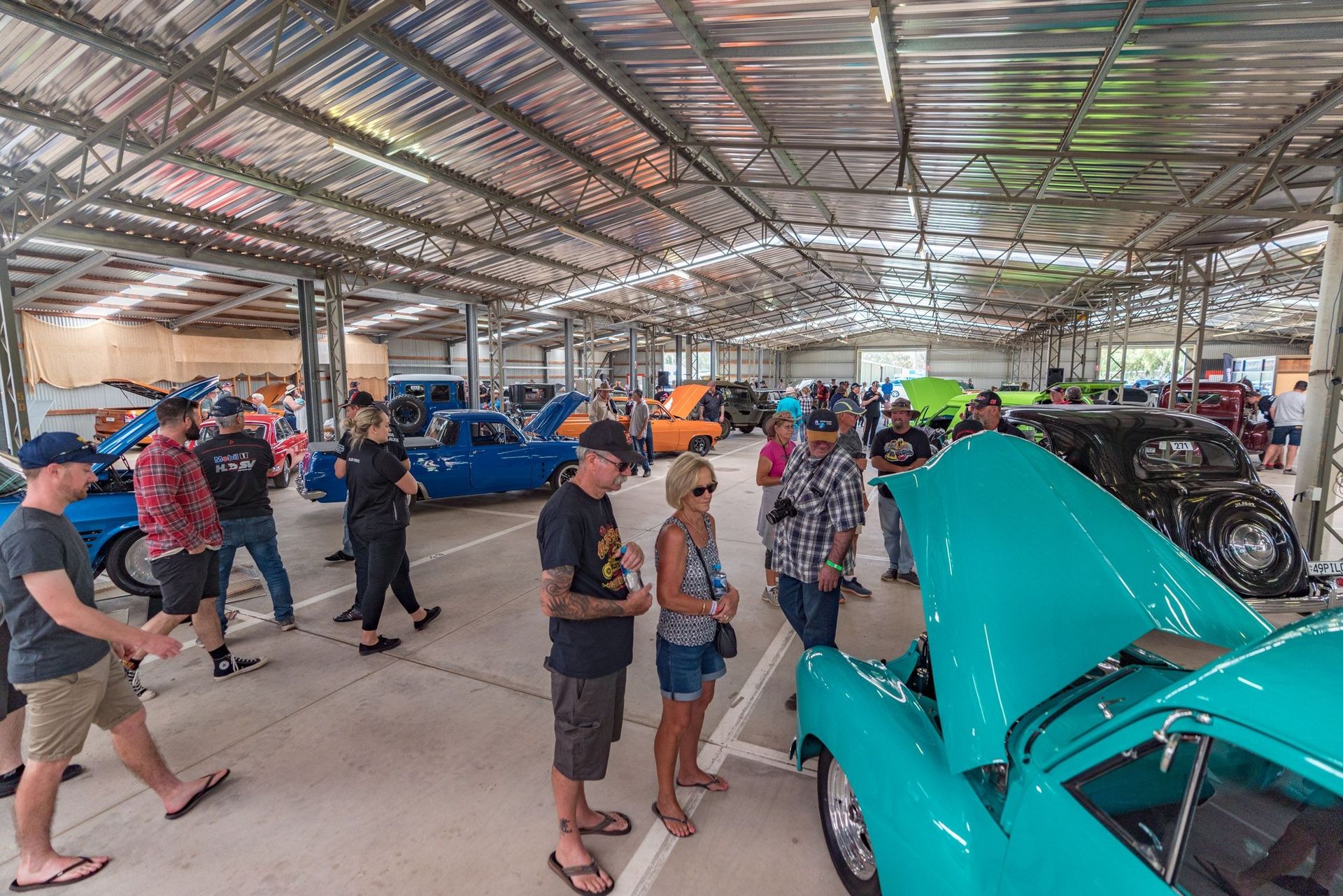 People Browsing Classic Cars in A Large Indoor Garage — Blatherskite Park in Ilparpa, NT