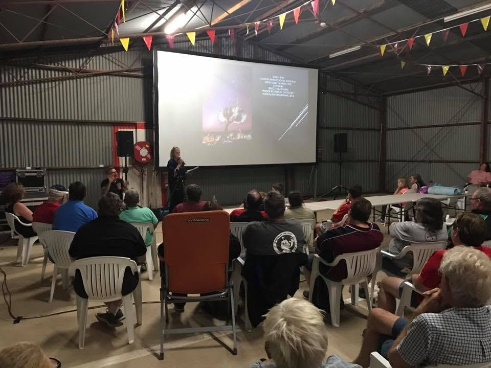 Audience Seated in A Hall Watching a Presentation Projected on A Large Screen — Blatherskite Park in Ilparpa, NT