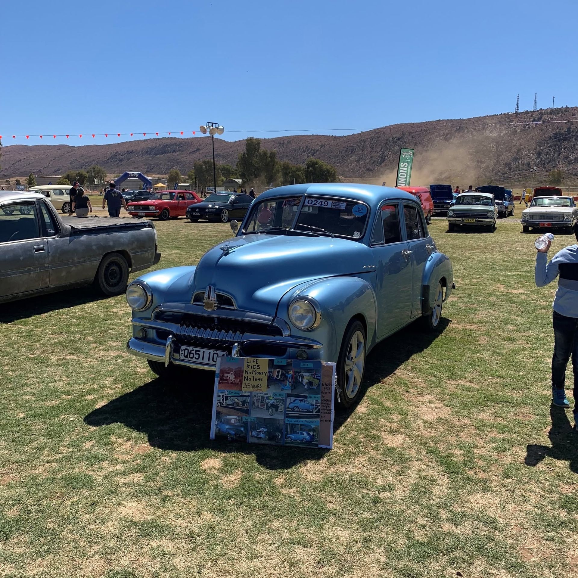 Light Blue Vintage Car at An Outdoor Car Show on A Grassy Field with Mountains — Blatherskite Park in Ilparpa, NT