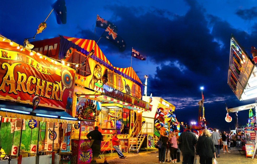 Bright Carnival Fairground at Night with Colorful Rides and People Walking Between Attractions — Blatherskite Park in Ilparpa, NT