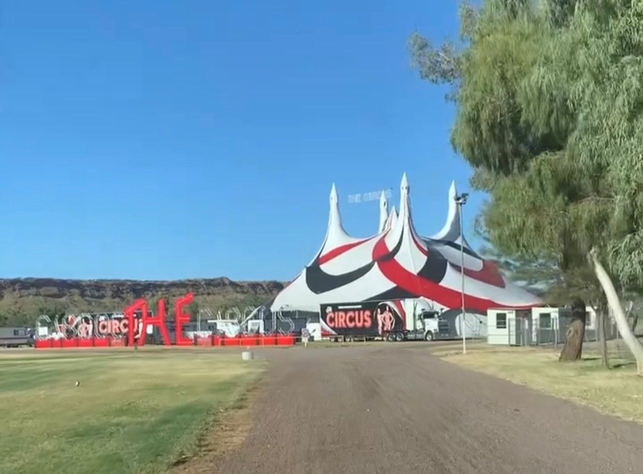 Large White And Red Circus Tent with Circus Signage Beside a Dirt Road — Blatherskite Park in Ilparpa, NT