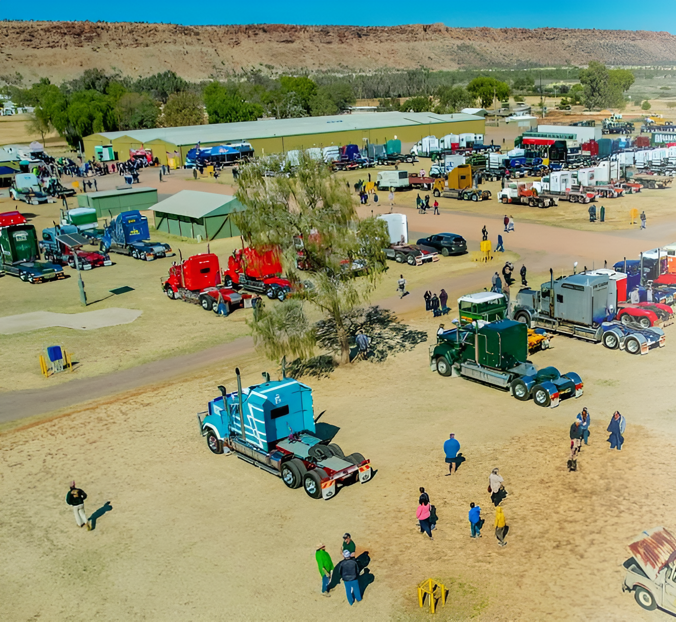 Busy Desert Truck Show with Colorful Semi Trucks, Tents, and People Gathered on Sandy Ground — Blatherskite Park in Ilparpa, NT