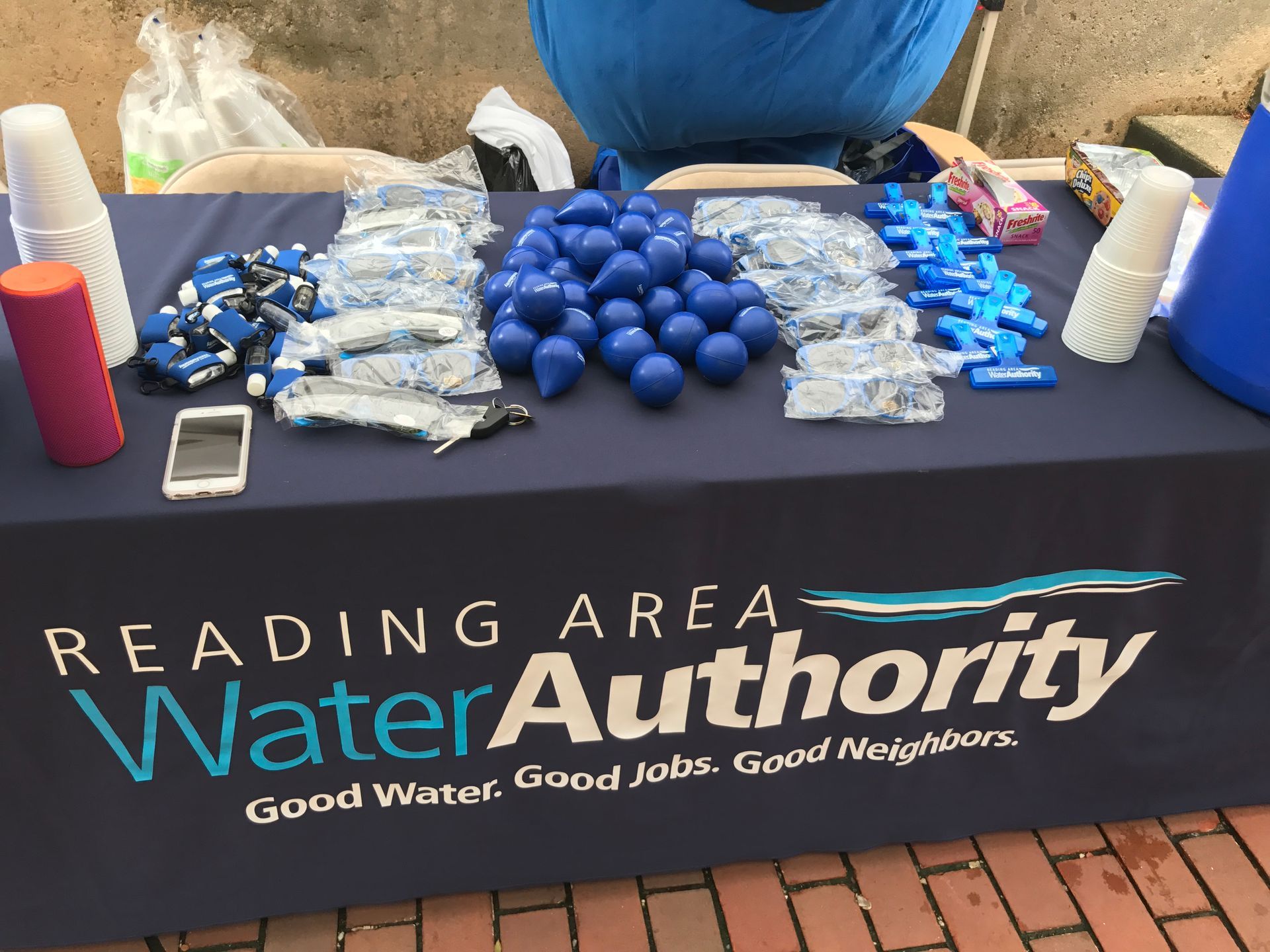 Table with Reading Area Water Authority logo, blue balloons, and giveaways.