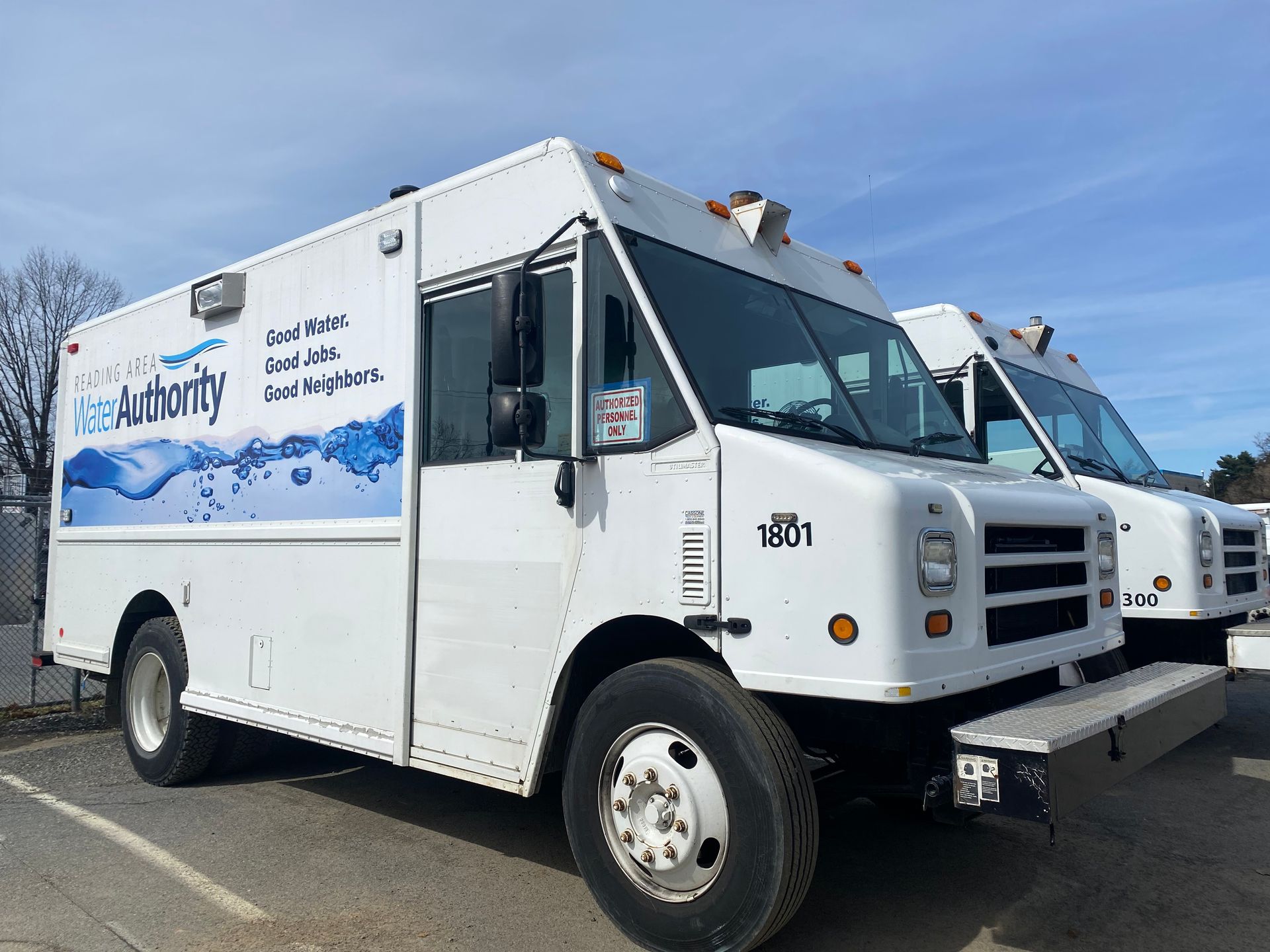 White water utility truck parked outside on a sunny day with blue and white graphic on the side.