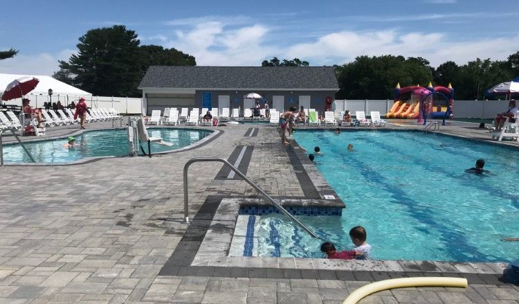 A group of people are swimming in a large swimming pool.