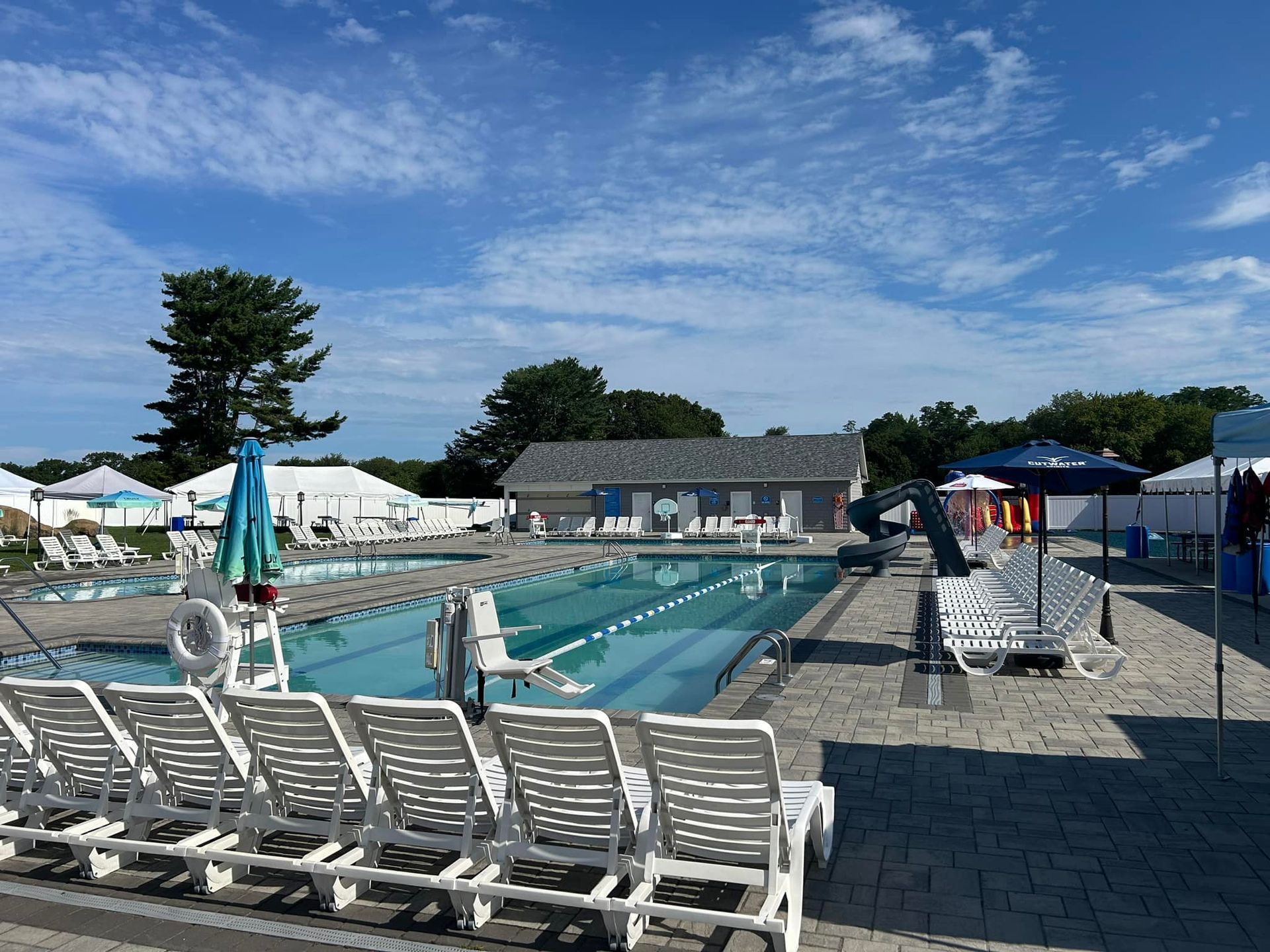A large swimming pool surrounded by chairs and umbrellas