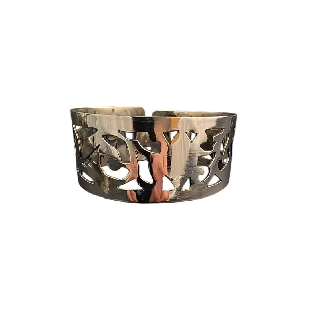 Brazalete de filigrana de plata con diseño de hoja calada y espiral.