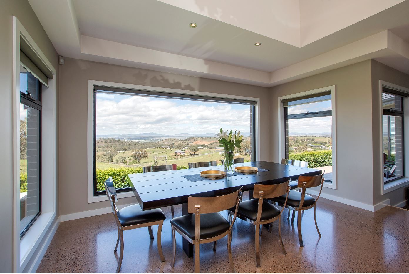 A dining room with a table and chairs and a large window
