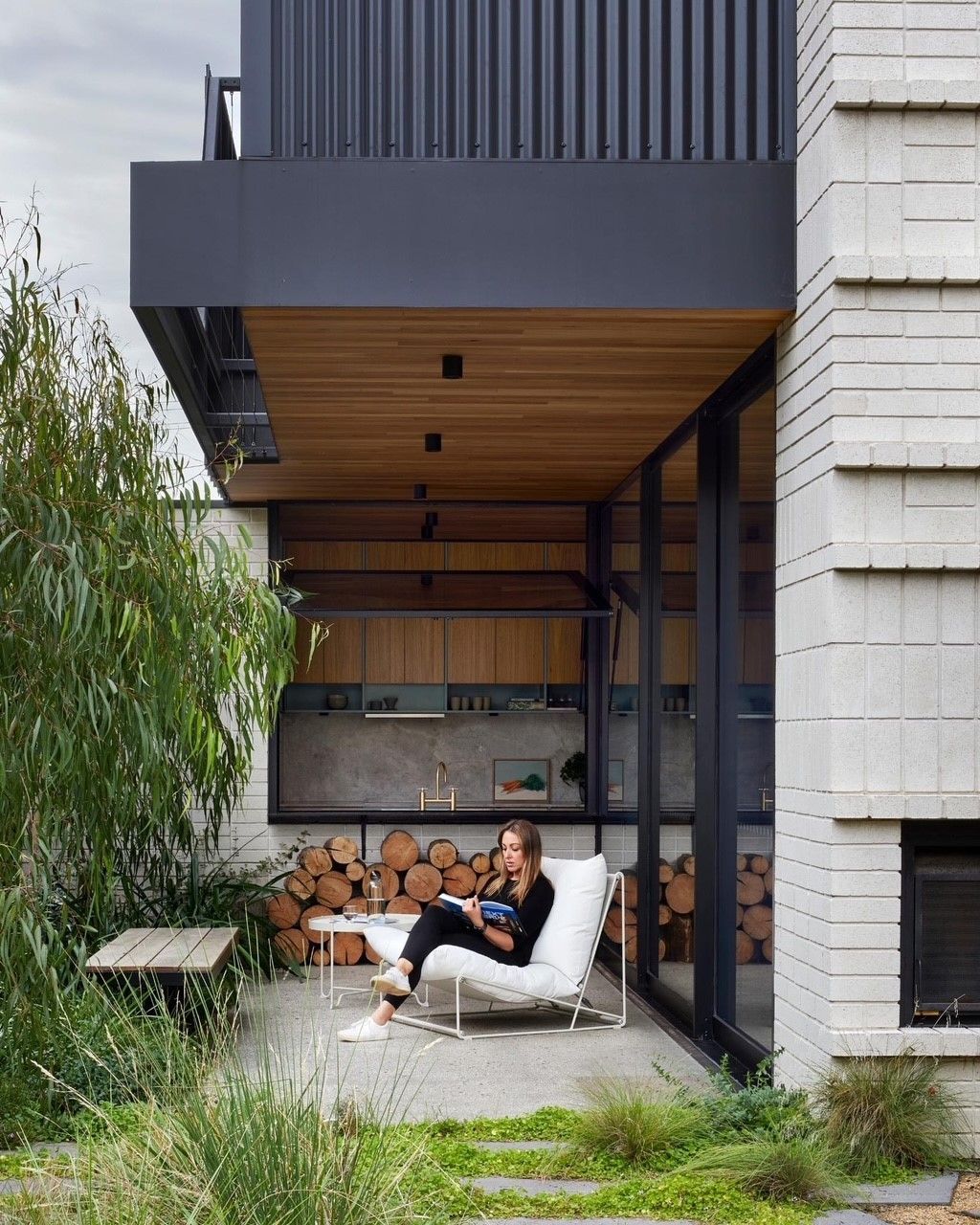 A woman is sitting on a chair outside of a house