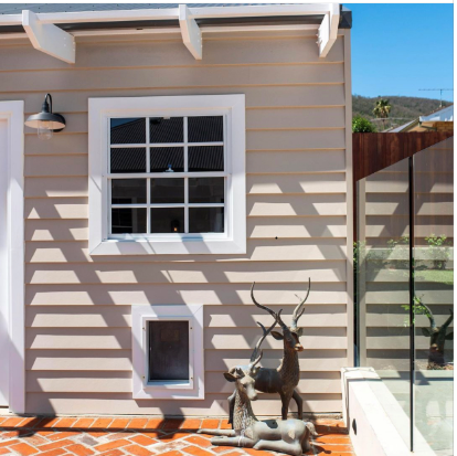 A house with two deer statues on the side of it