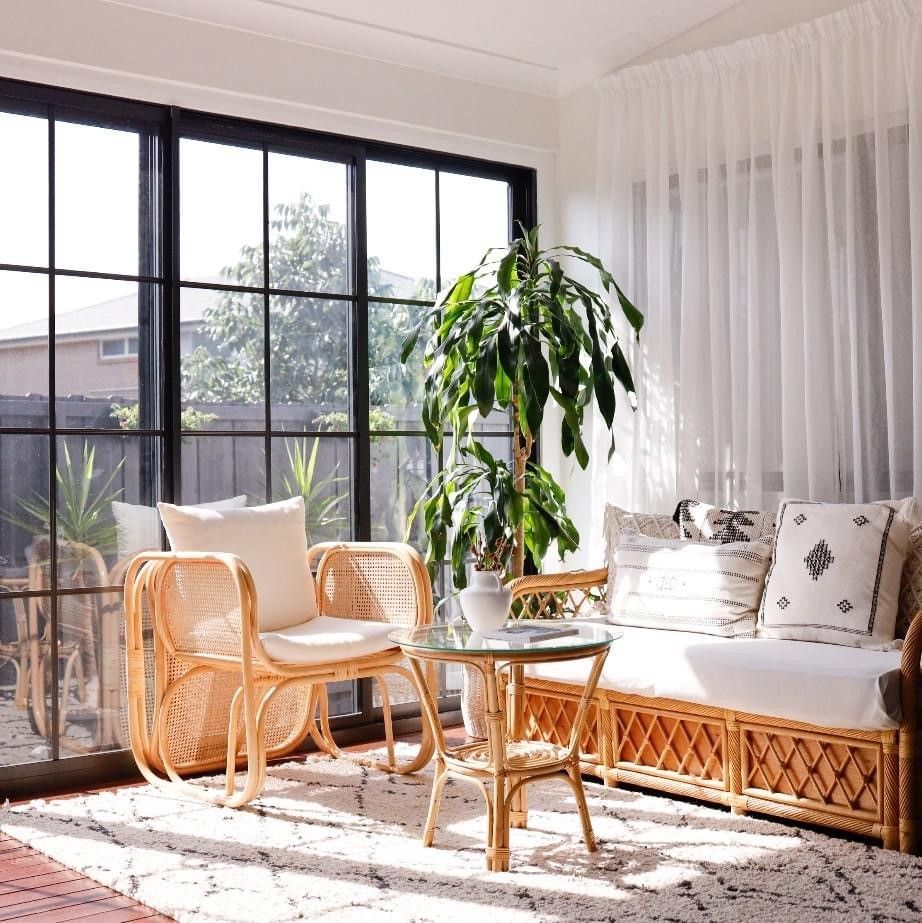 A living room with a couch , chair , table and potted plant.