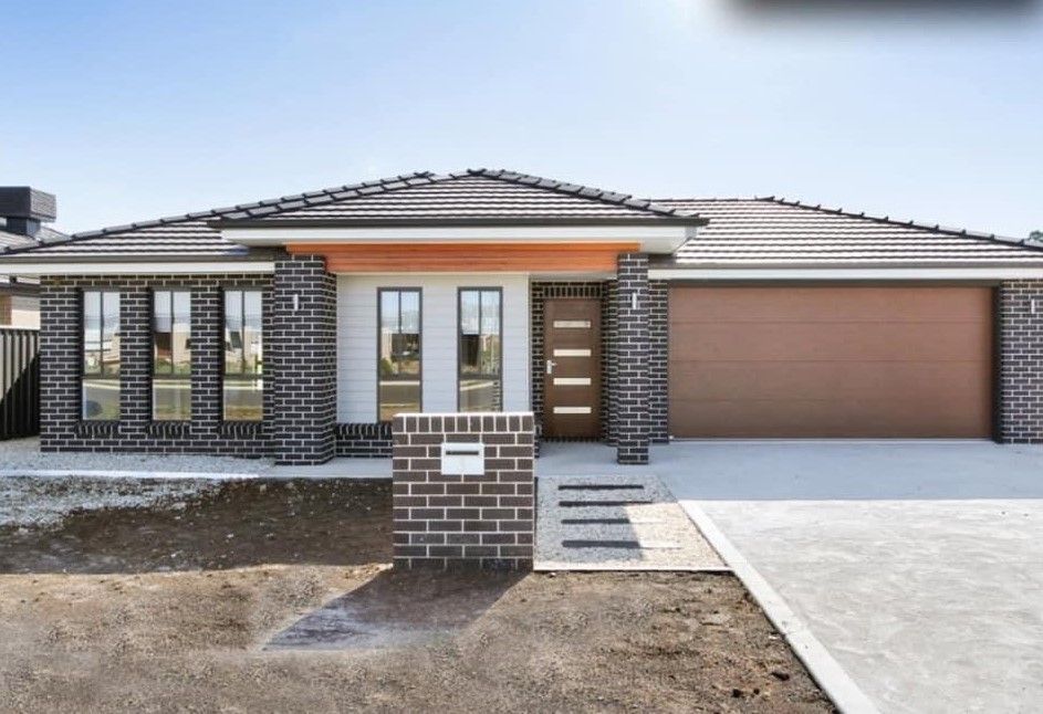 A large brick house with a brown garage door