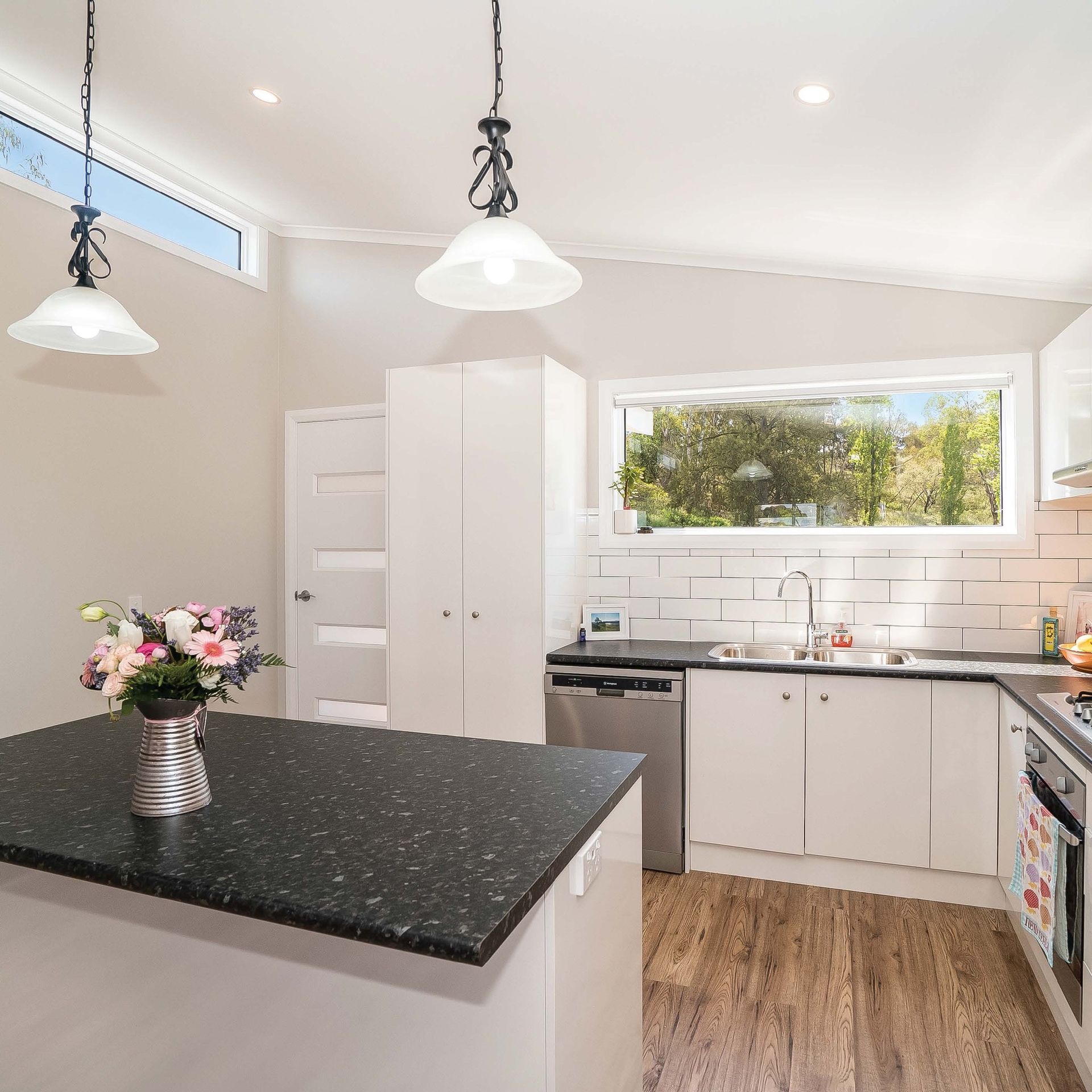 A kitchen with a vase of flowers on the counter